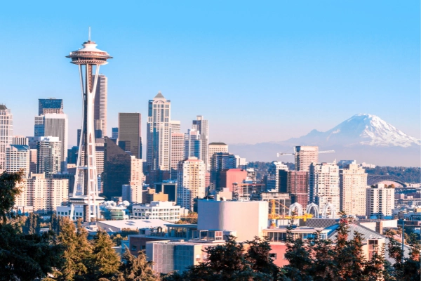 Seattle skyline with Space Needle and Mount Rainier in the background on a clear day.