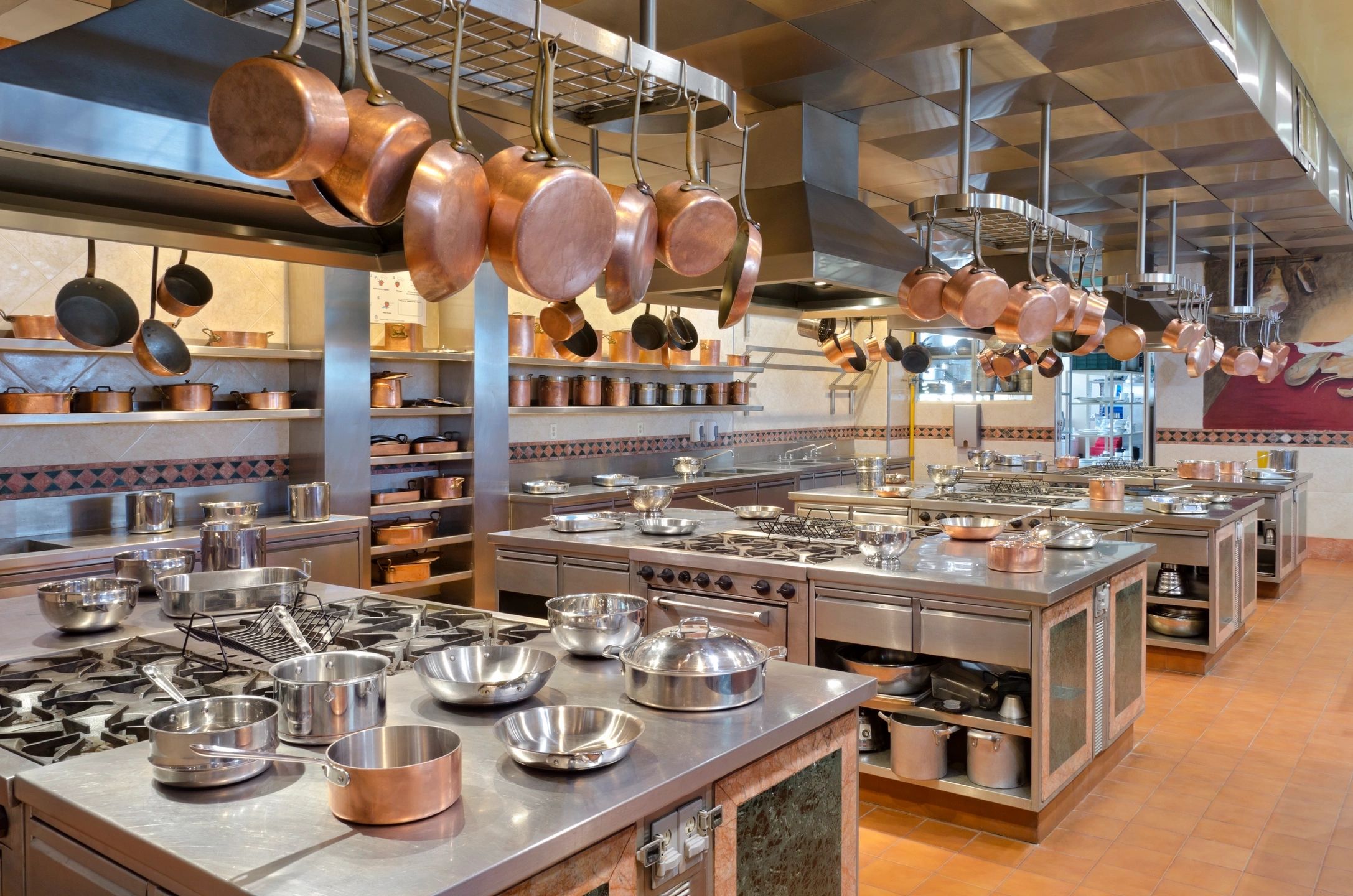 Spotless commercial kitchen with clean cooking equipment and organized food prep areas, emphasizing restaurant cleaning services.