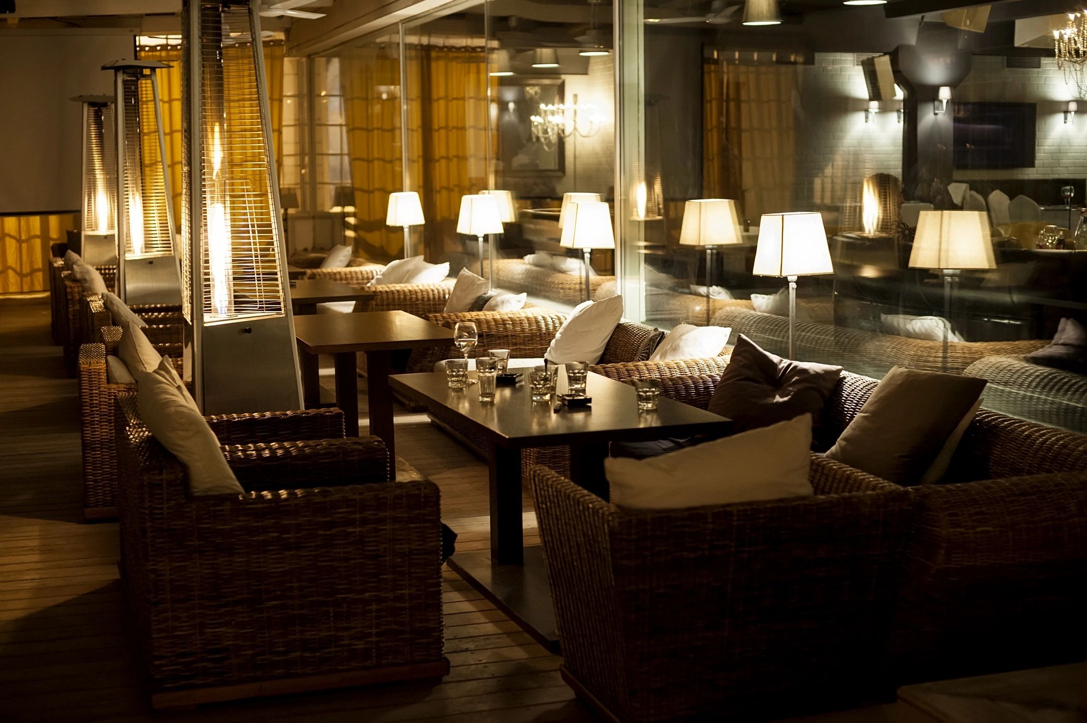 Cozy, dimly-lit restaurant lounge with wicker furniture and warm lighting, creating an inviting atmosphere.