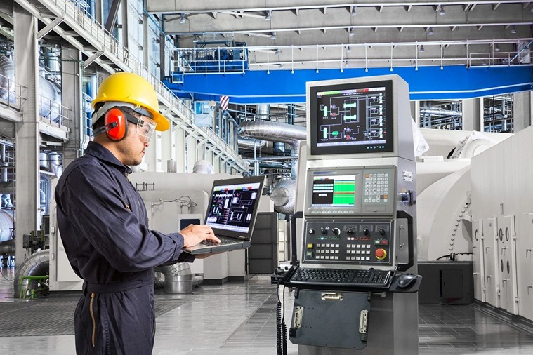 A technician monitoring machinery in a clean power plant using advanced technology.