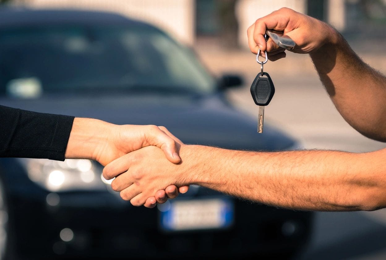 Car keys being handed over in a clean showroom, showcasing professional showroom floor cleaning and maintenance.