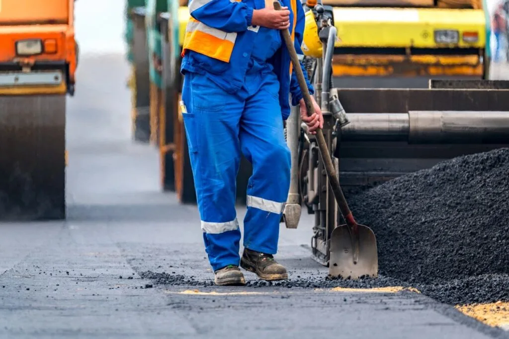 Worker maintaining an industrial worksite, illustrating the importance of cleanliness and safety in industrial environments.