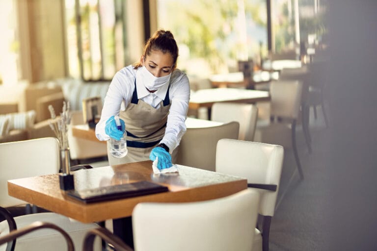 Professional cleaner sanitizing a restaurant table during a commercial cleaning service in Portland, OR