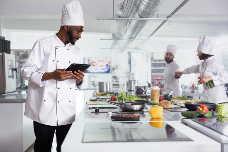 Restaurant cleaning services in Miami FL — spotless commercial kitchen with chefs preparing dishes in a sanitized food prep area