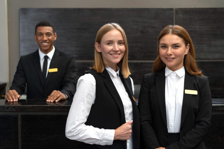 Hotel front desk team in uniform welcoming guests at a Portland hotel reception